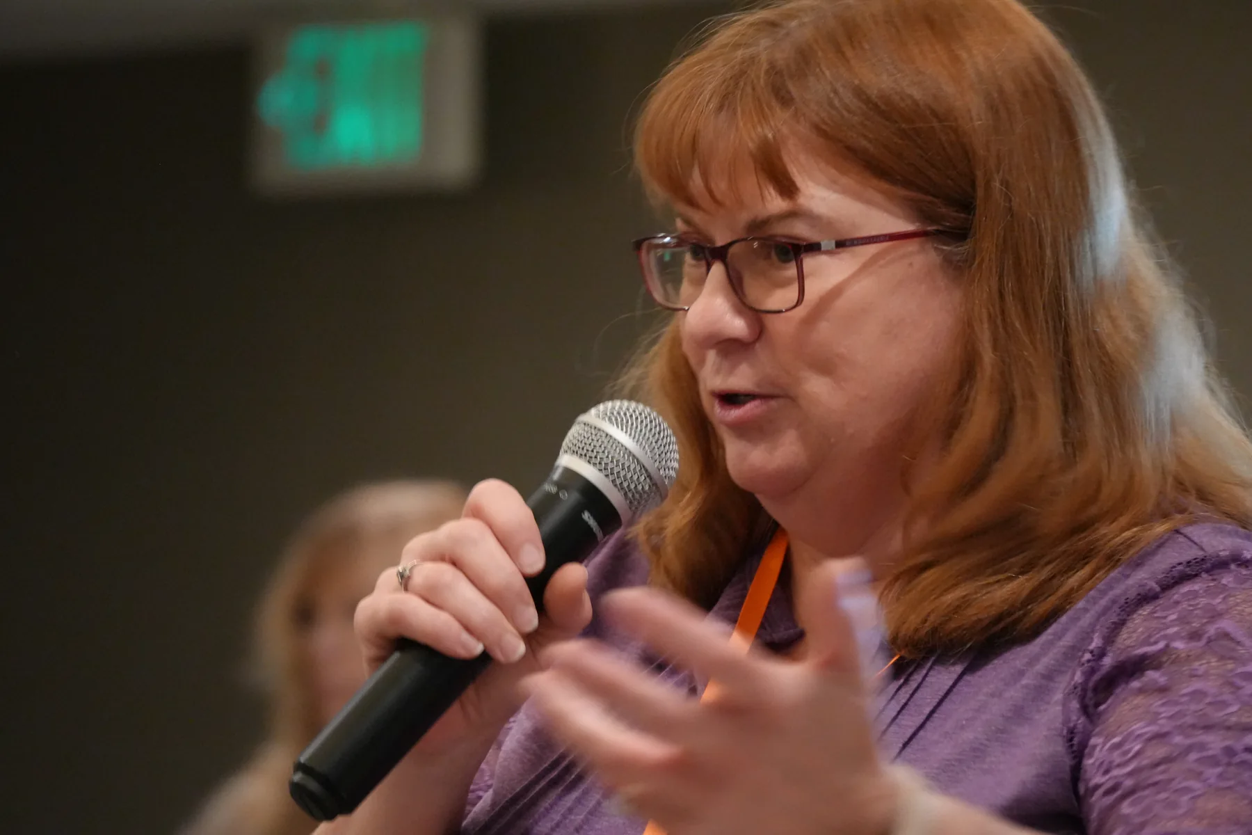 Pam speaking into a microphone.