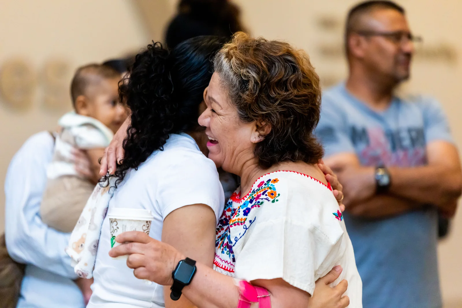 Two people embrace at a community gathering.