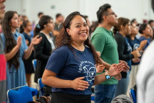 A woman smiling among people gathered at a congregation event