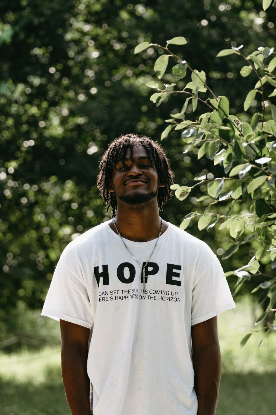 A young man in a HOPE shirt standing outdoors