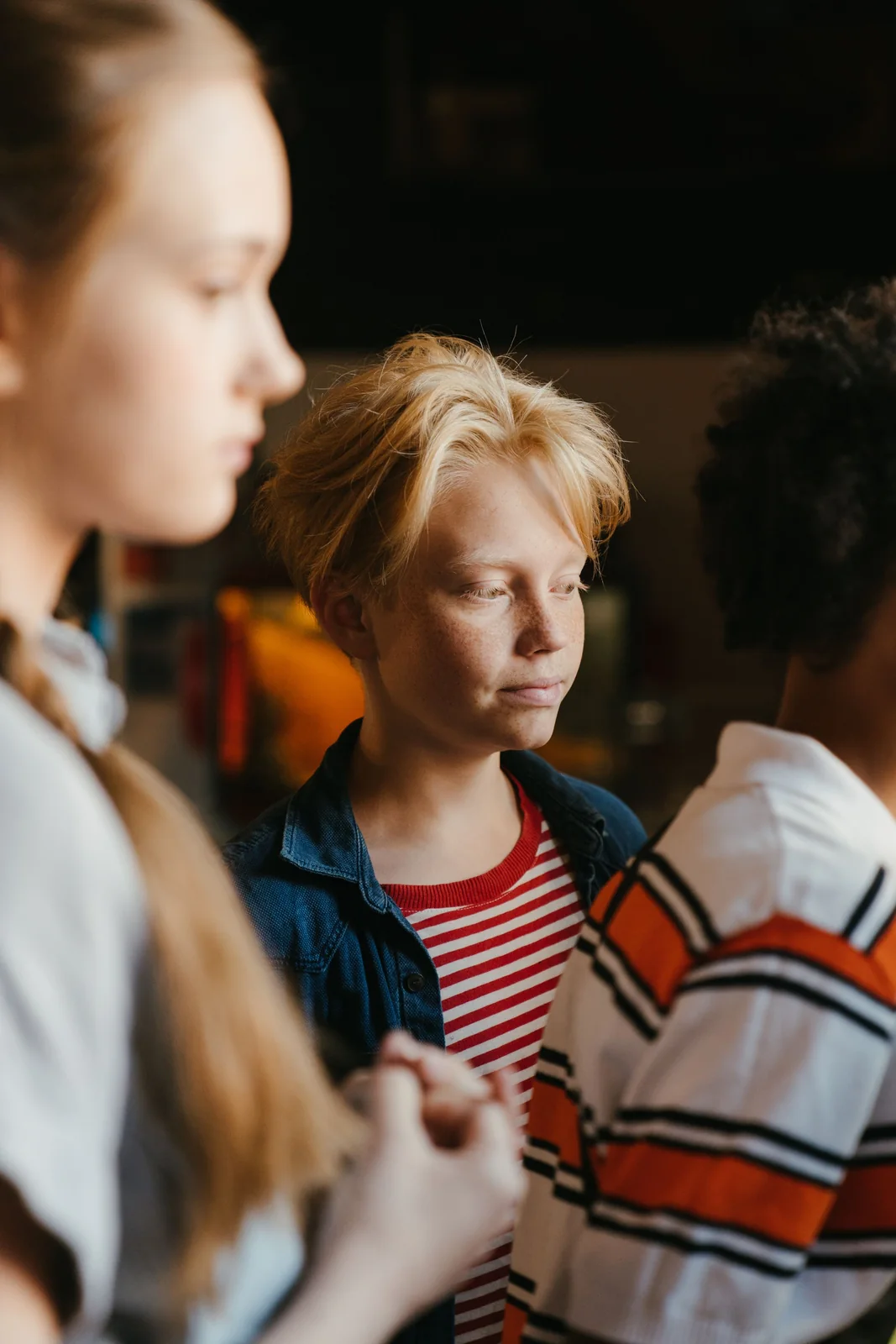 A young adult talking with peers indoors