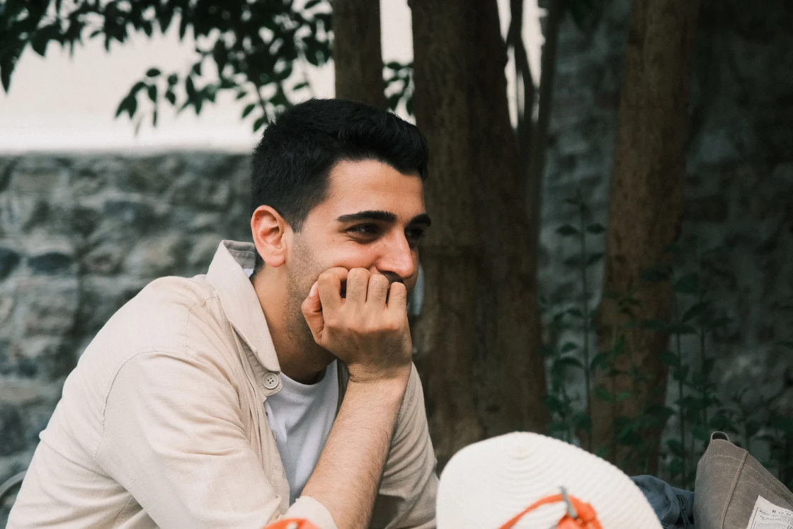 A man listening thoughtfully outdoors.