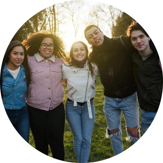 Five young people standing together outdoors.